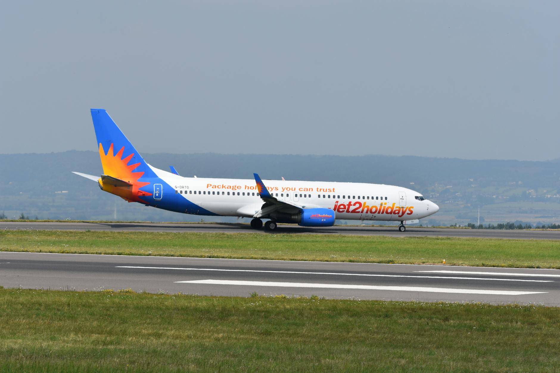 Jet2holidays airplane on the runway ready for takeoff at a scenic airport.
