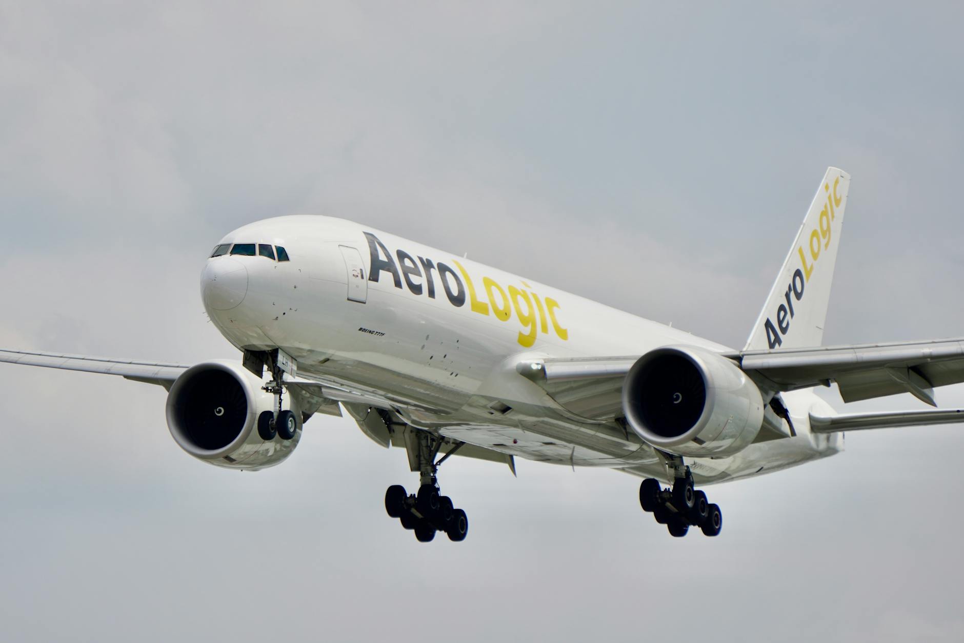 Close-up view of an AeroLogic cargo plane mid-flight against a cloudy sky.