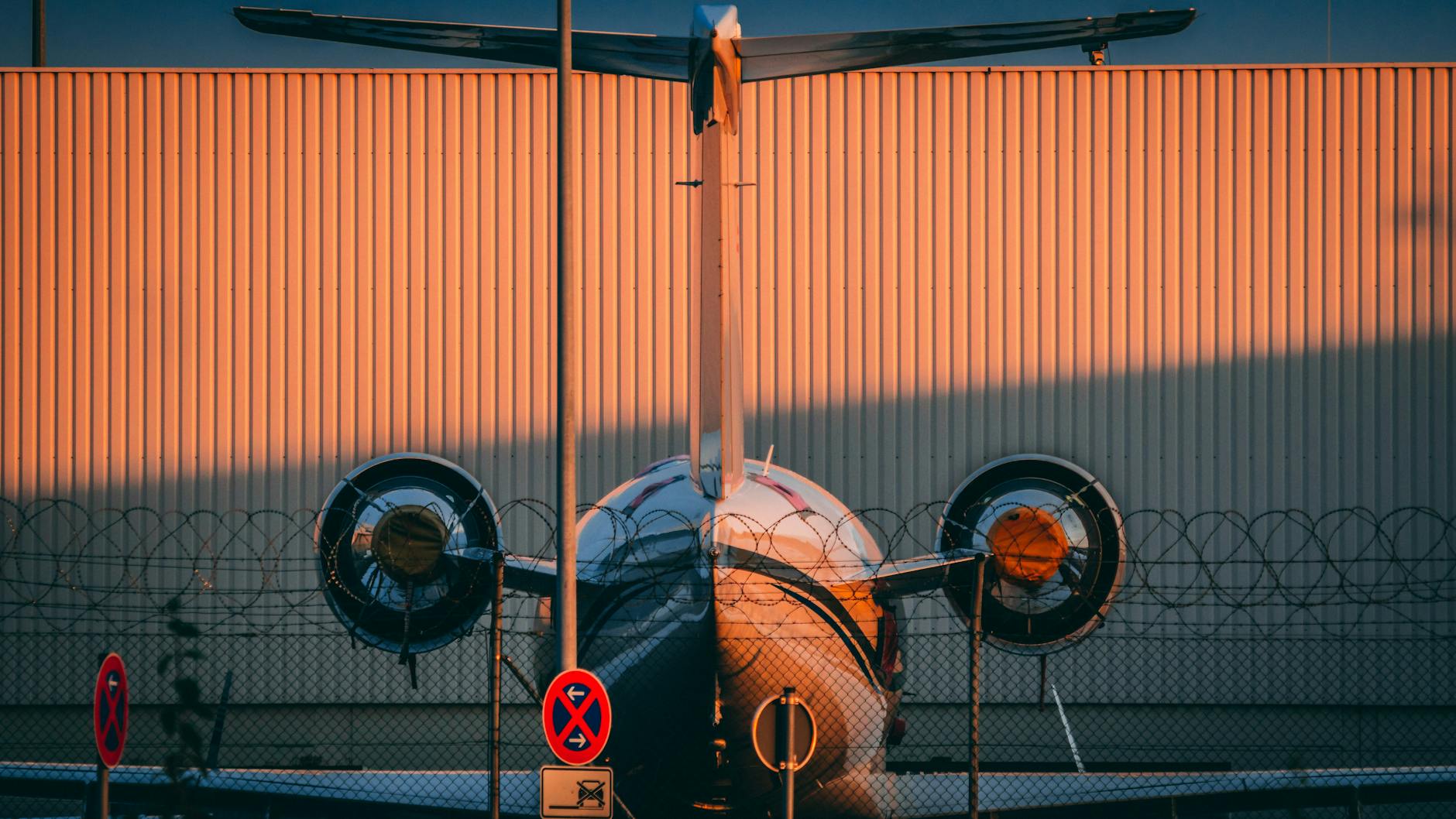 Twin jet airplane parked on Nürnberg airport apron at sunset.