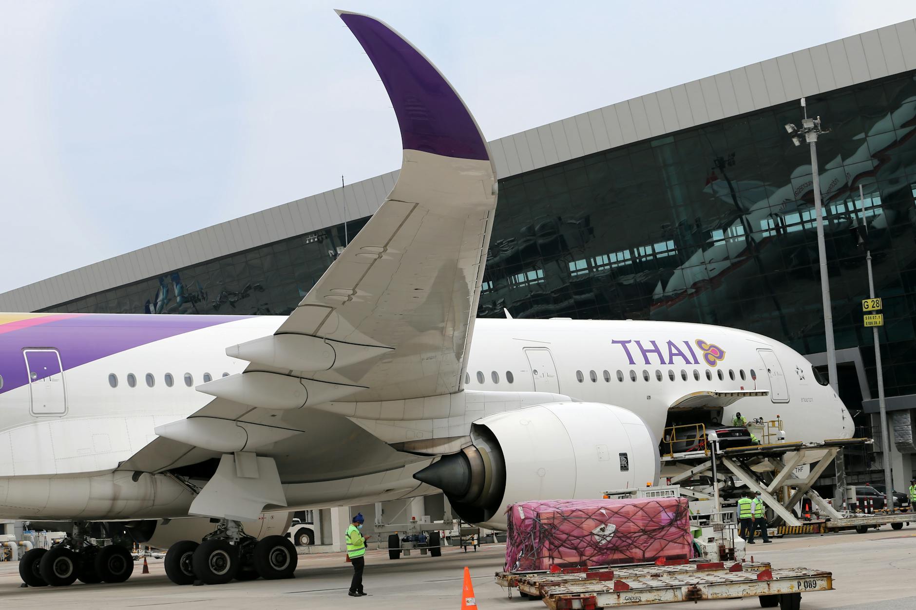 Side view of Thai Airways Airbus at an airport, featuring visible engine and wing.