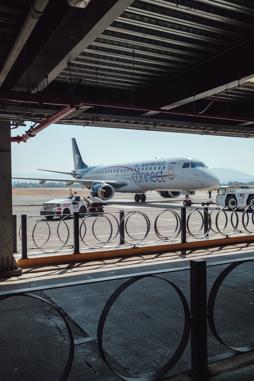 An airplane parked on the runway at an airport, captured during the day with clear skies.