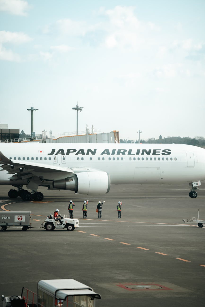 Japan Airlines plane on runway with crew at Ota City Airport, Tokyo.
