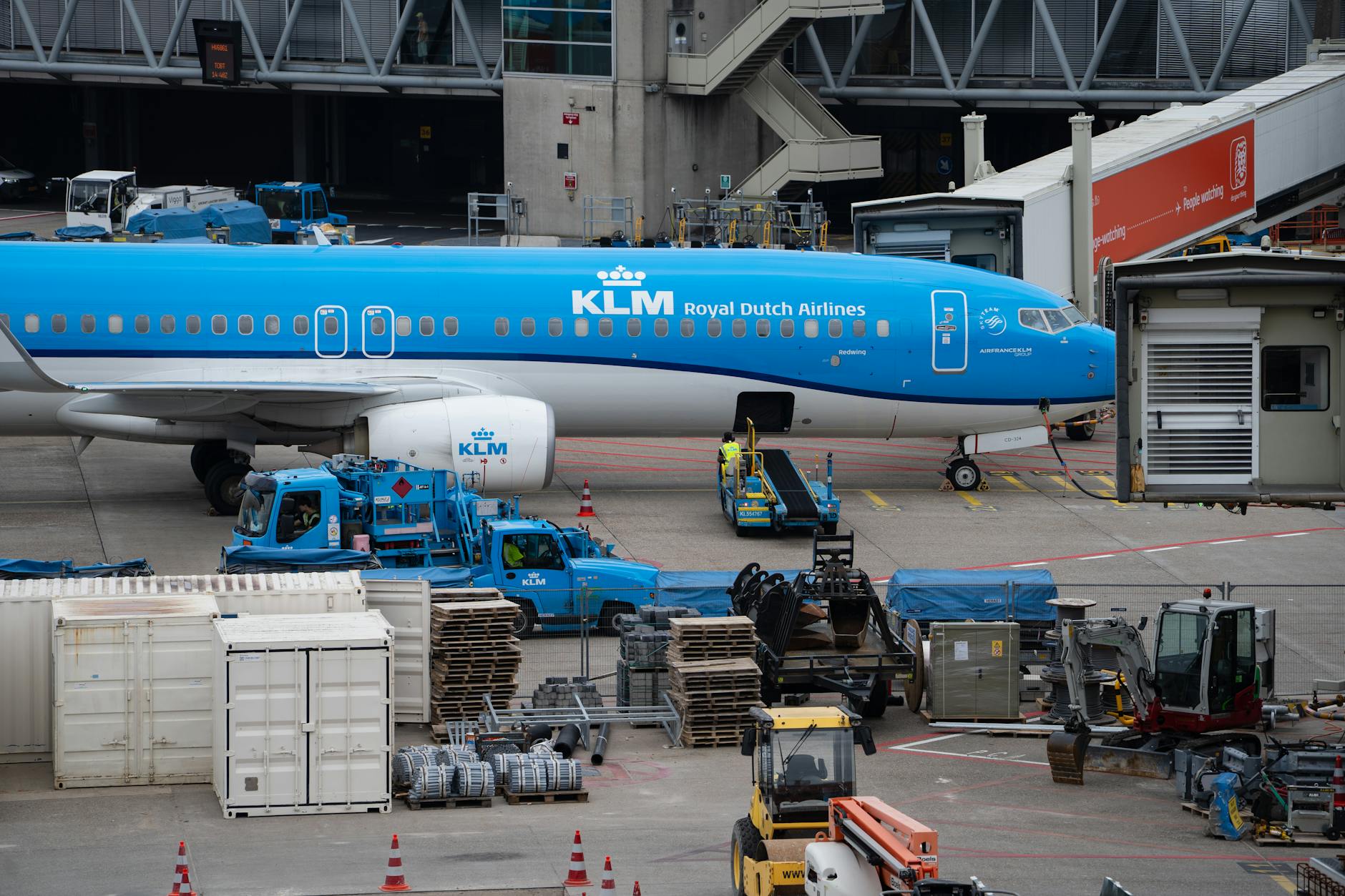 KLM Royal Dutch Airlines airplane docked at a busy airport terminal.