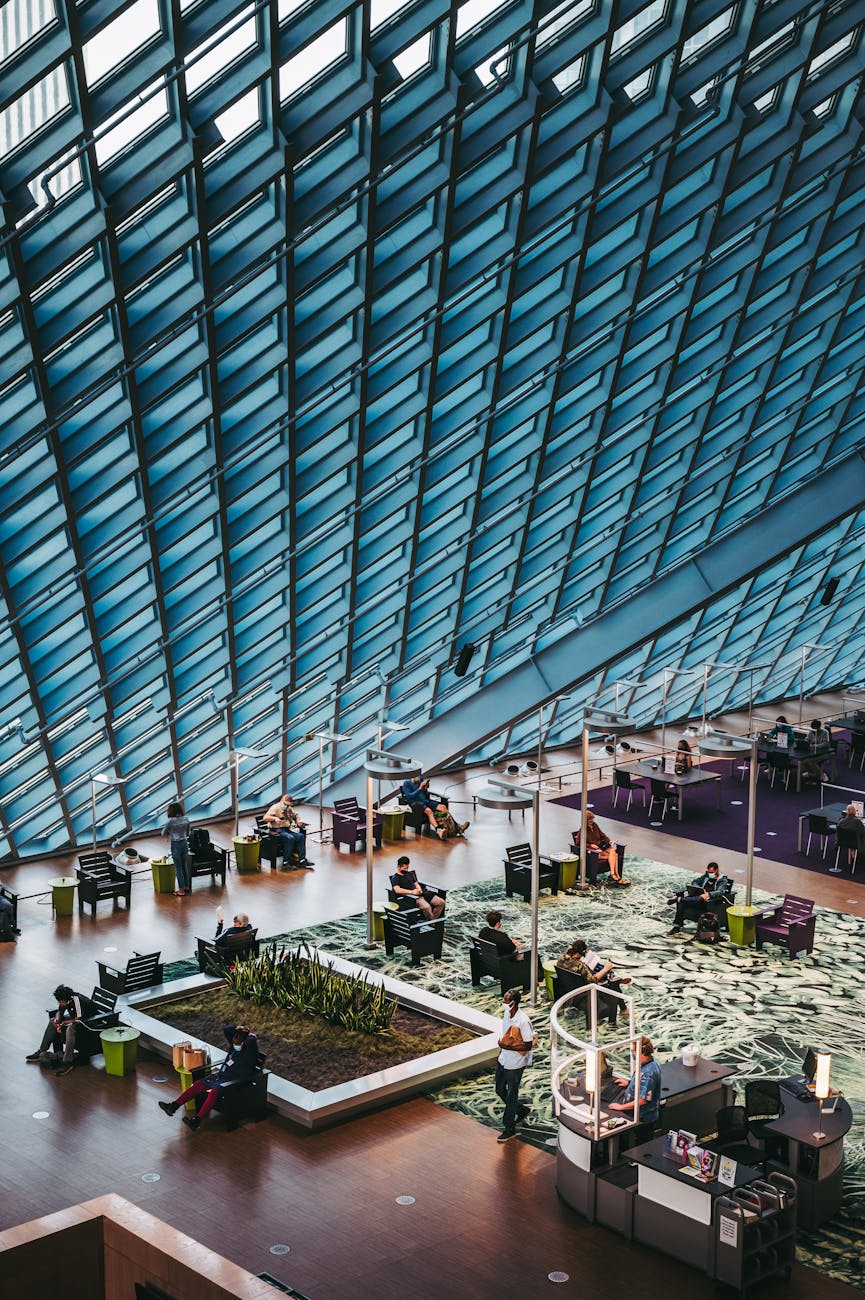 Spacious airport lounge featuring unique architecture and people waiting.