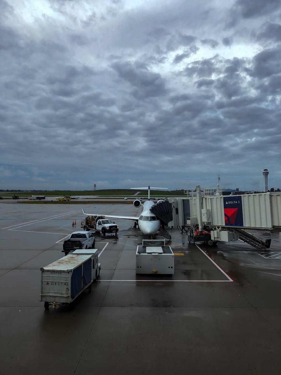 A small commercial jet stationed at a gate in Cincinnati airport on a cloudy day.