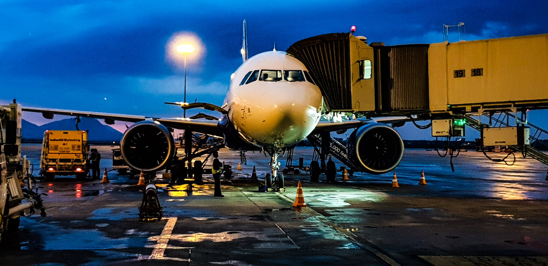 A commercial airplane on the runway at Bengaluru airport during night with a blue sky backdrop.