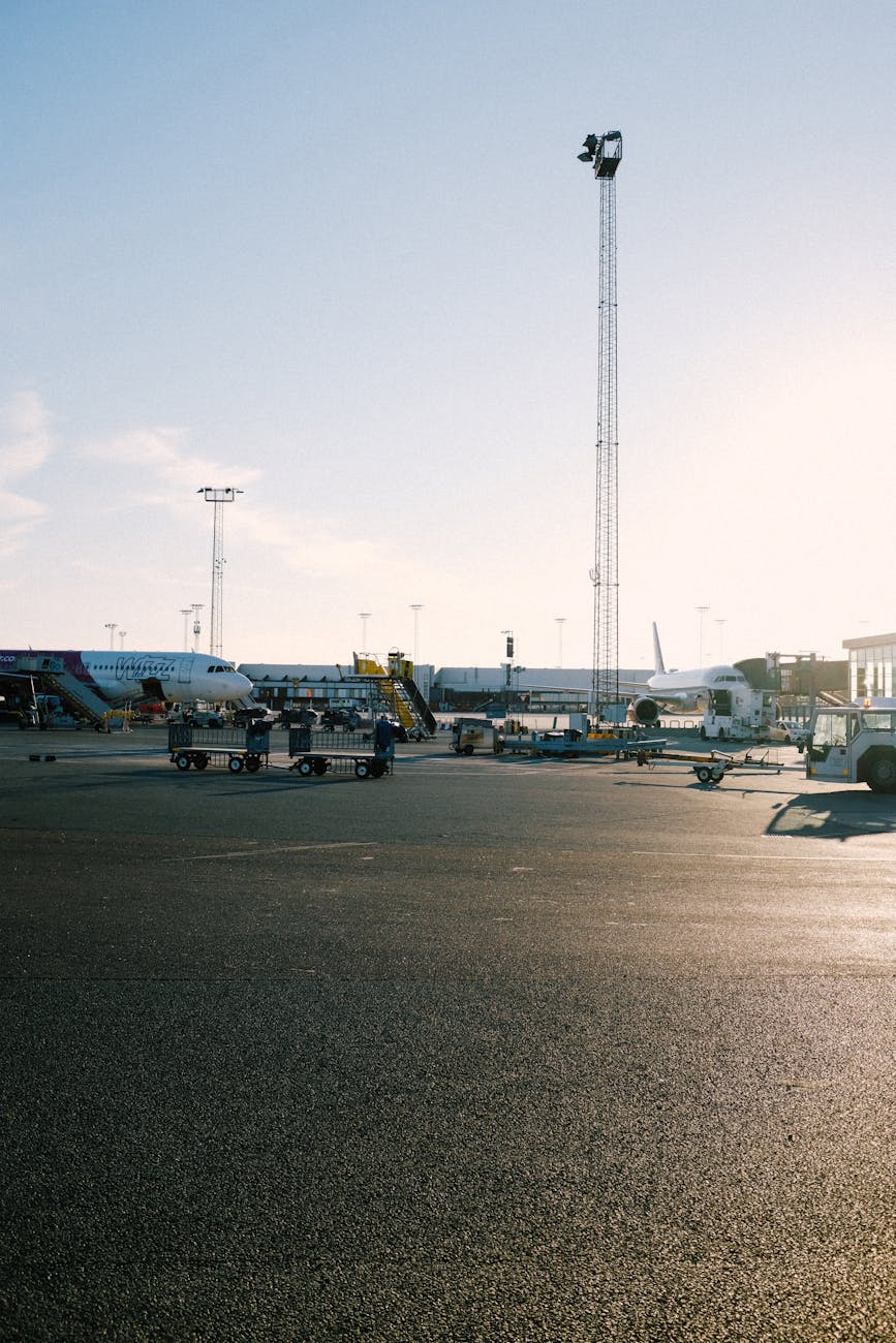 A busy airport tarmac featuring several airplanes during sunset, highlighting travel and transportation themes.