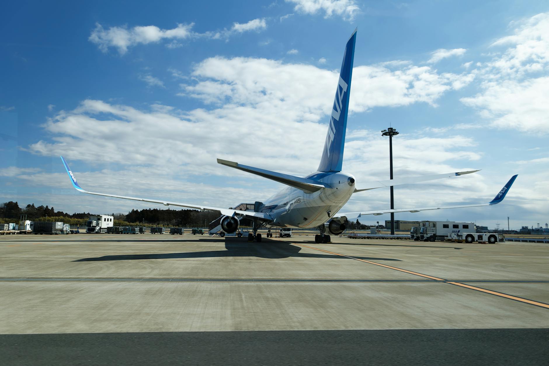 A large passenger airliner parked on the runway at a sunny airport.