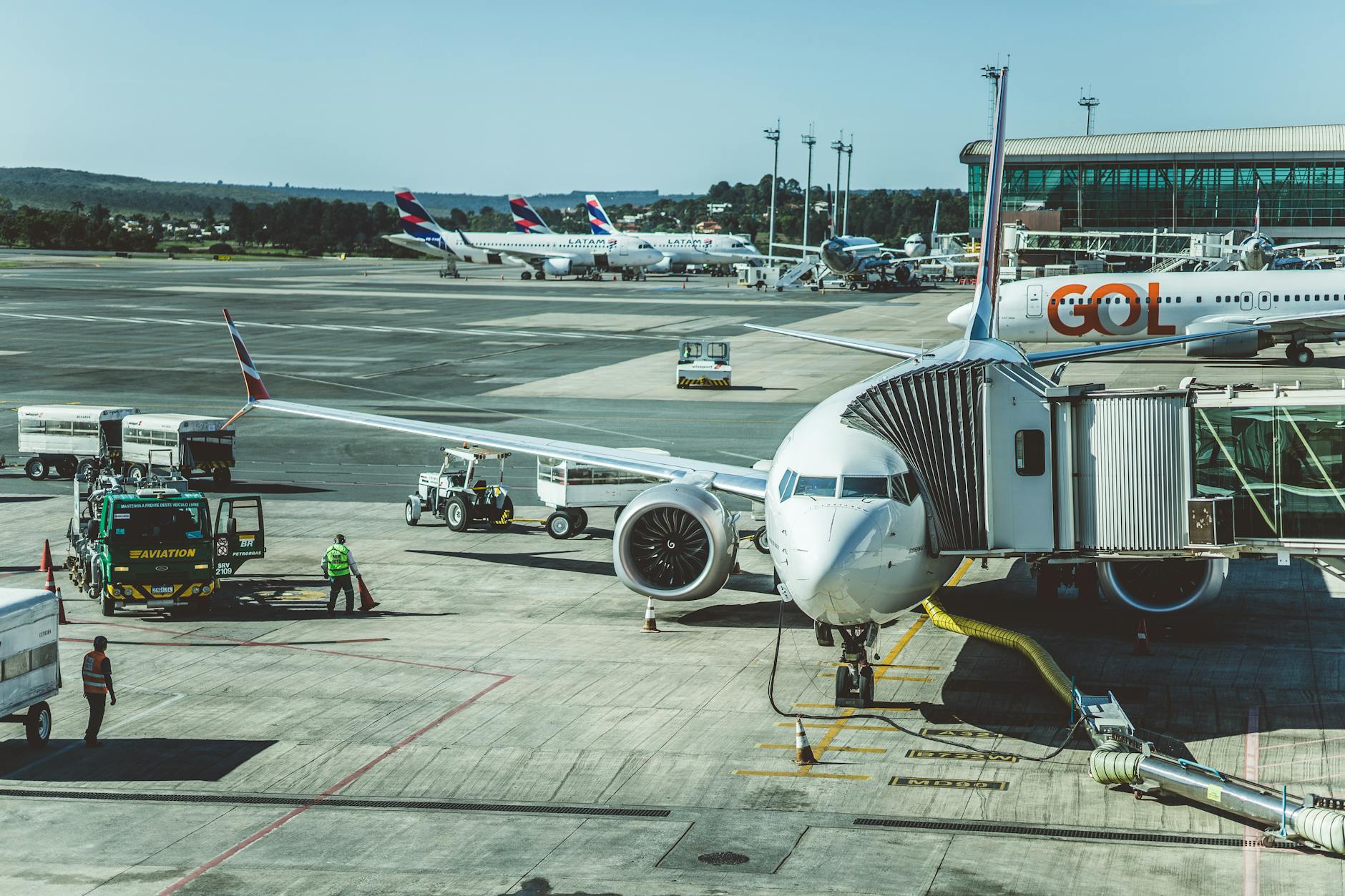 A scenic view of airplanes at an airport runway during a busy day, ready for boarding.