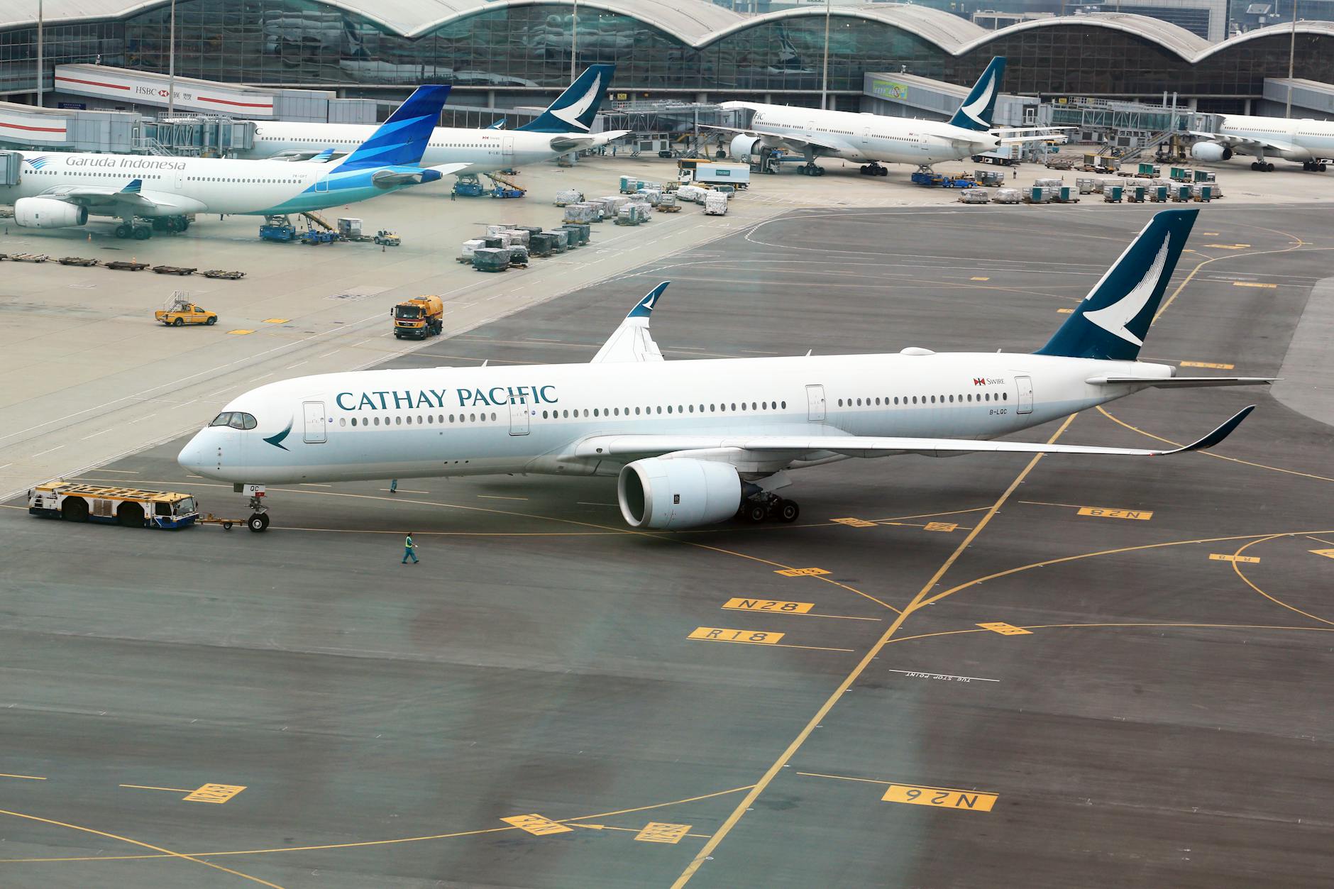 A Cathay Pacific plane stationed on the airport runway ready for departure.