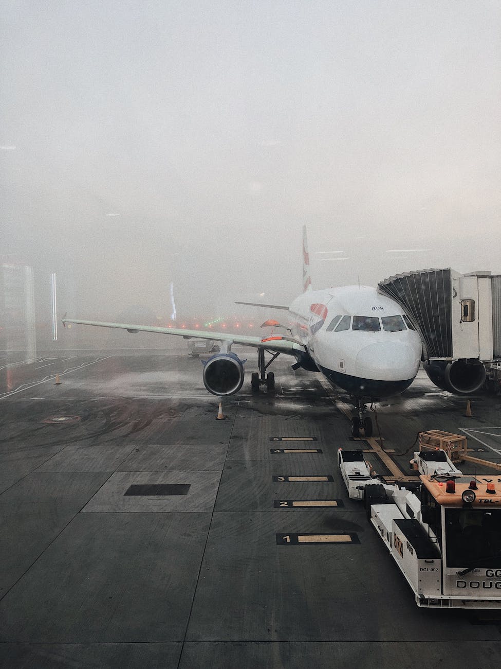 A commercial airplane on a foggy runway at Gatwick Airport, Horley, UK, ready for boarding.
