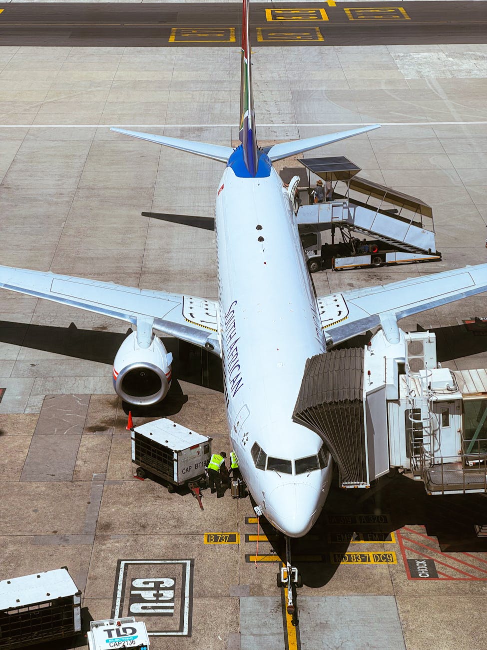 View of a commercial airplane at an airport gate, ready for boarding services.