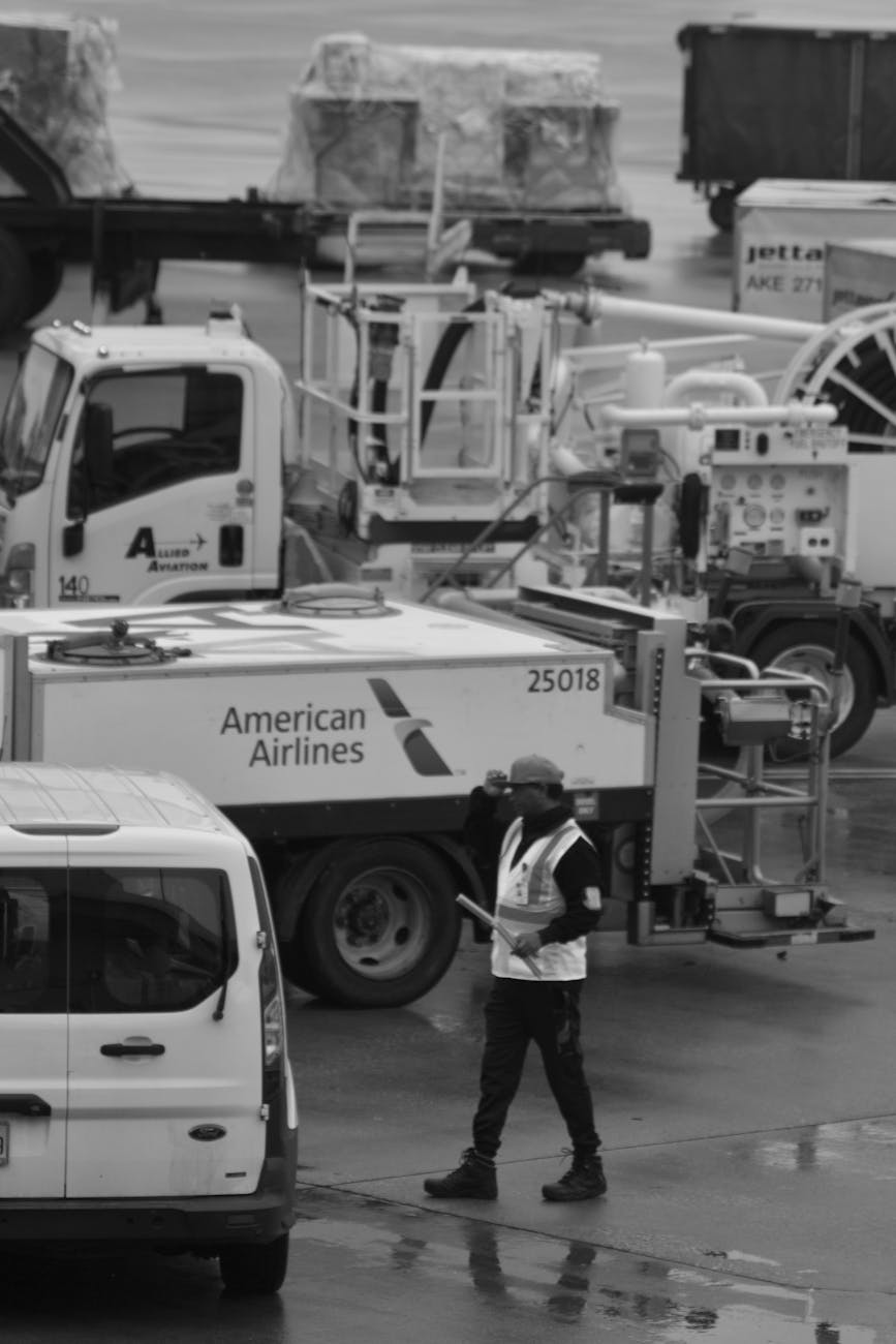 Black and white photo of airport ground crew near American Airlines vehicles.