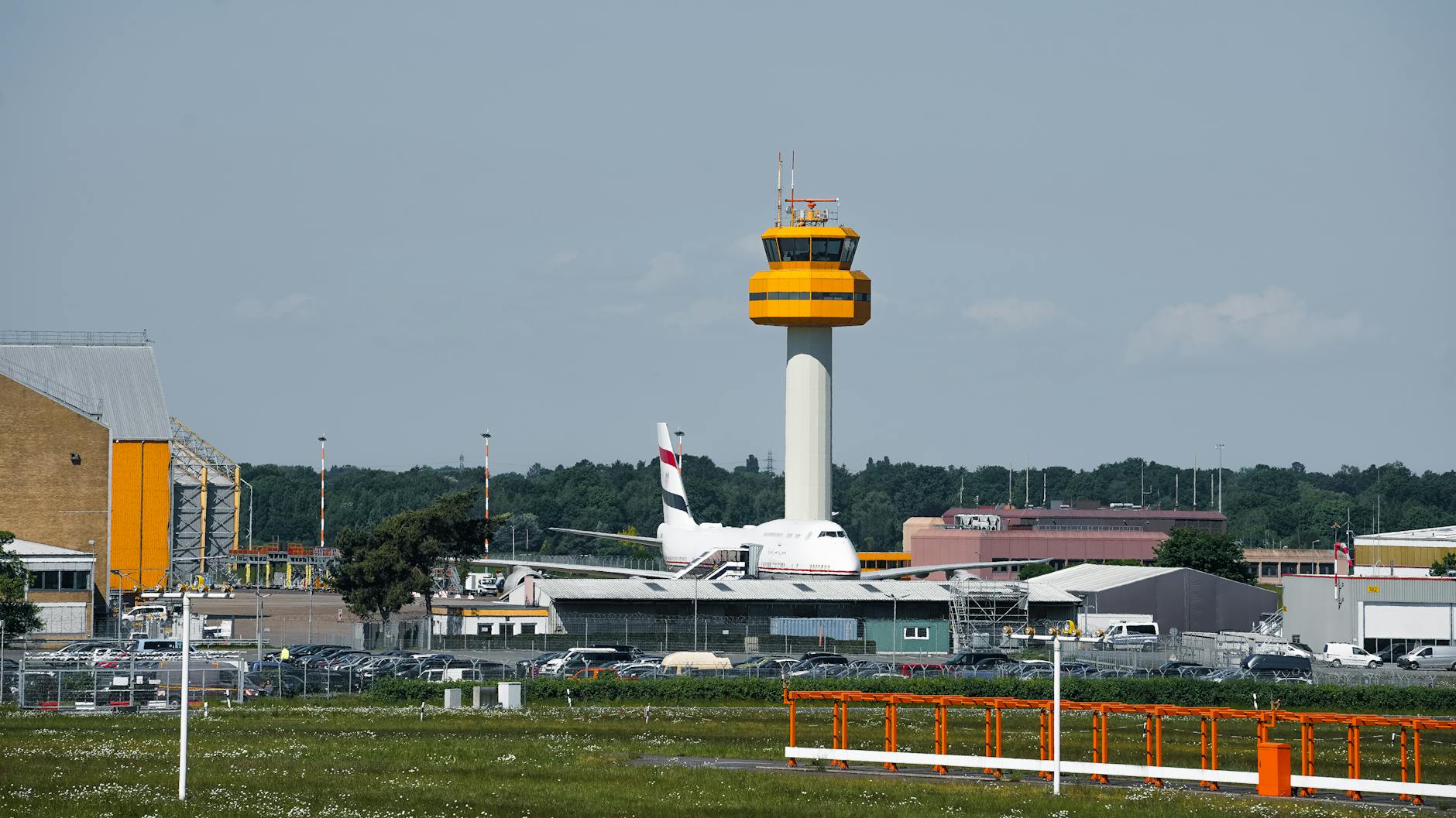 View of a control tower and airplane at Hamburg Airport on a sunny day.