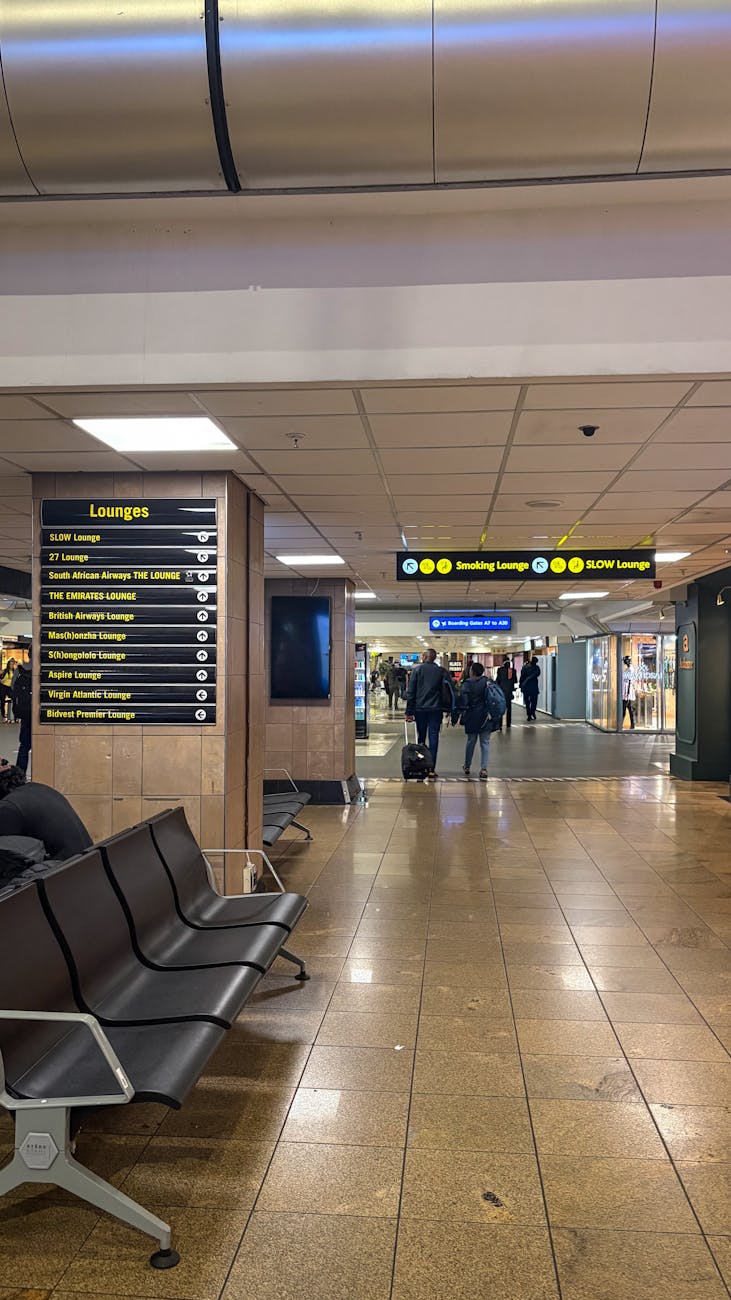 Modern airport interior showcasing seating and clear lounge signage for travelers.