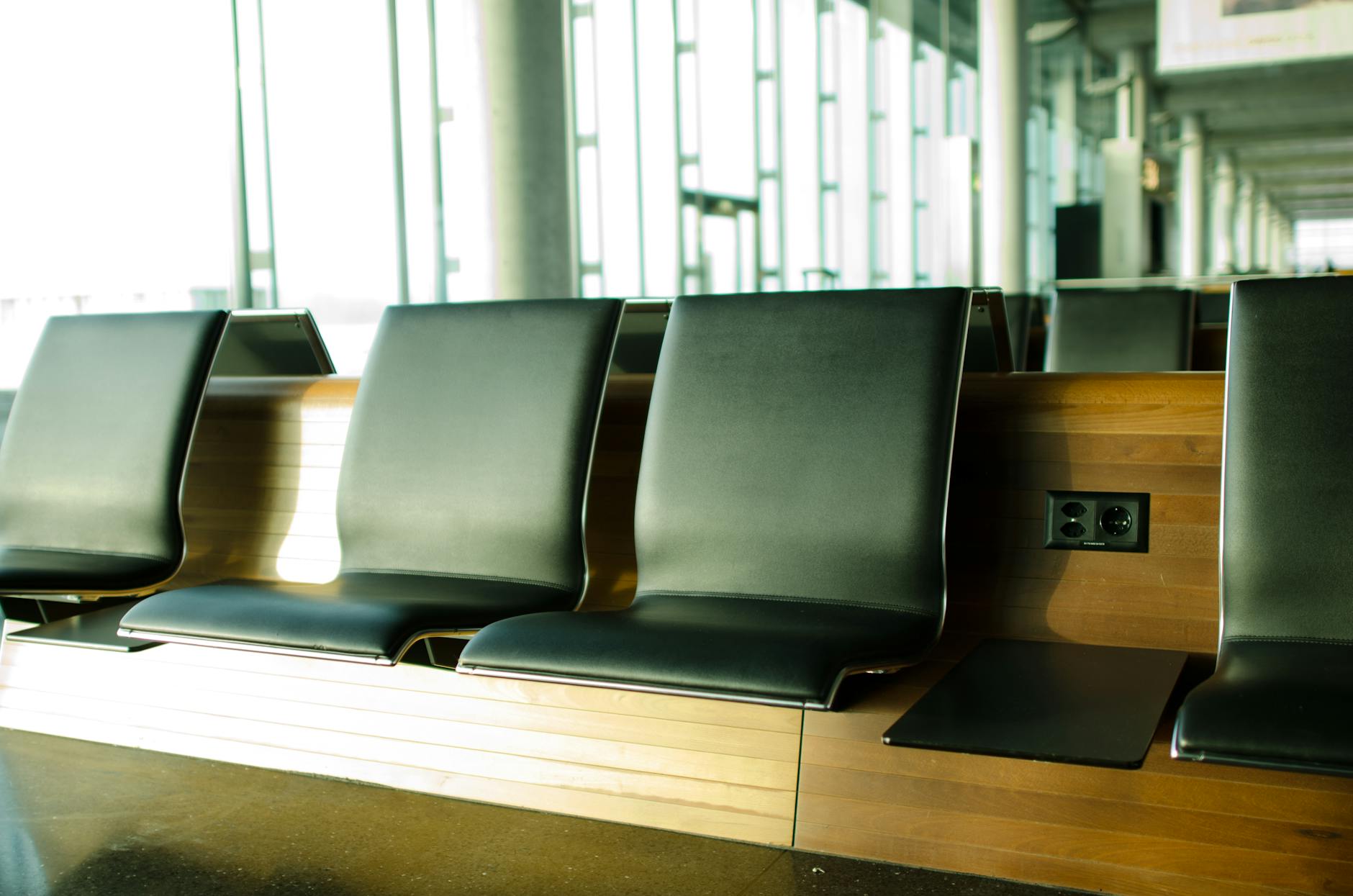 Empty airport seating area with sunlight streaming in, creating a tranquil atmosphere.