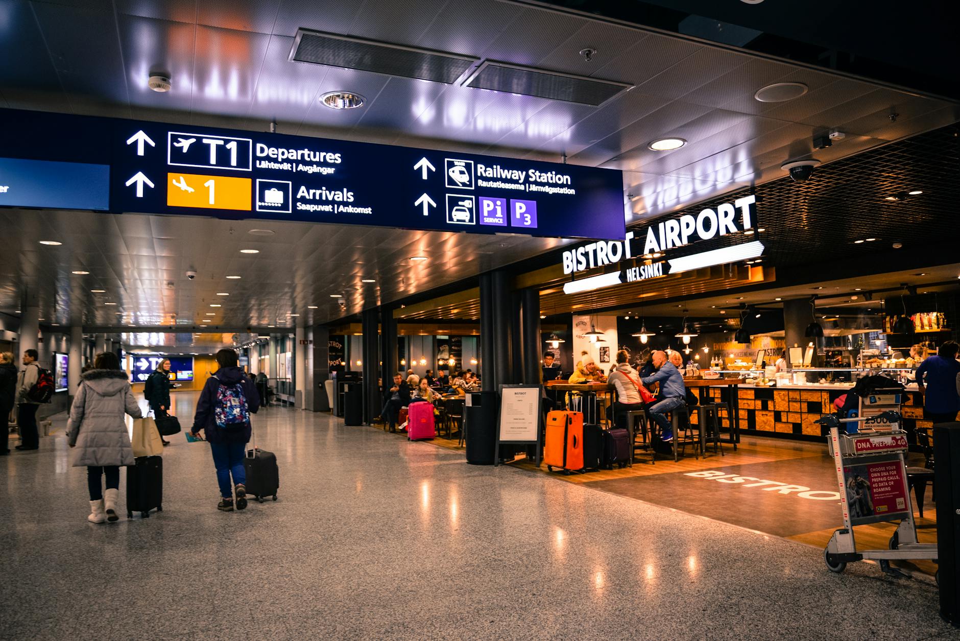 Travelers at Helsinki Airport dining and shopping near departures and arrivals.