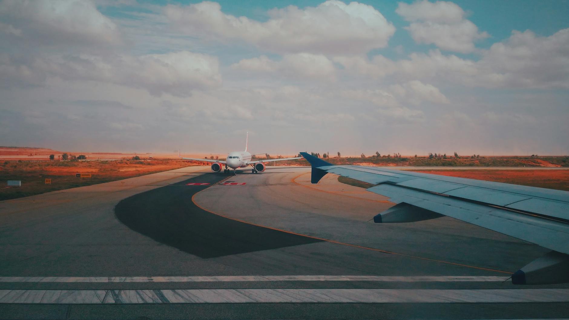 A runway scene with airplanes against a dramatic sunset sky, capturing aviation's essence.