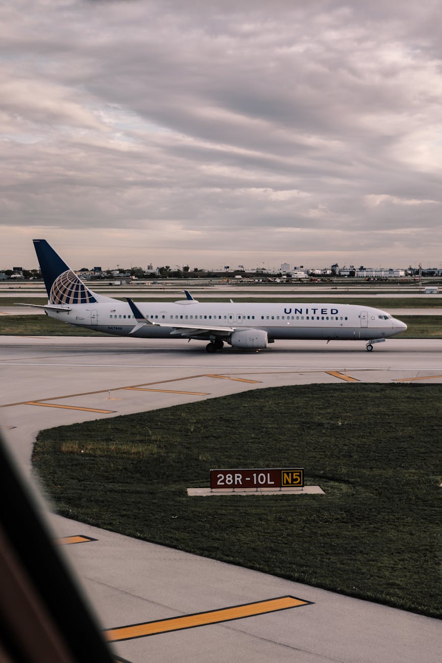 United Airlines aircraft taxiing on runway at an overcast airport.