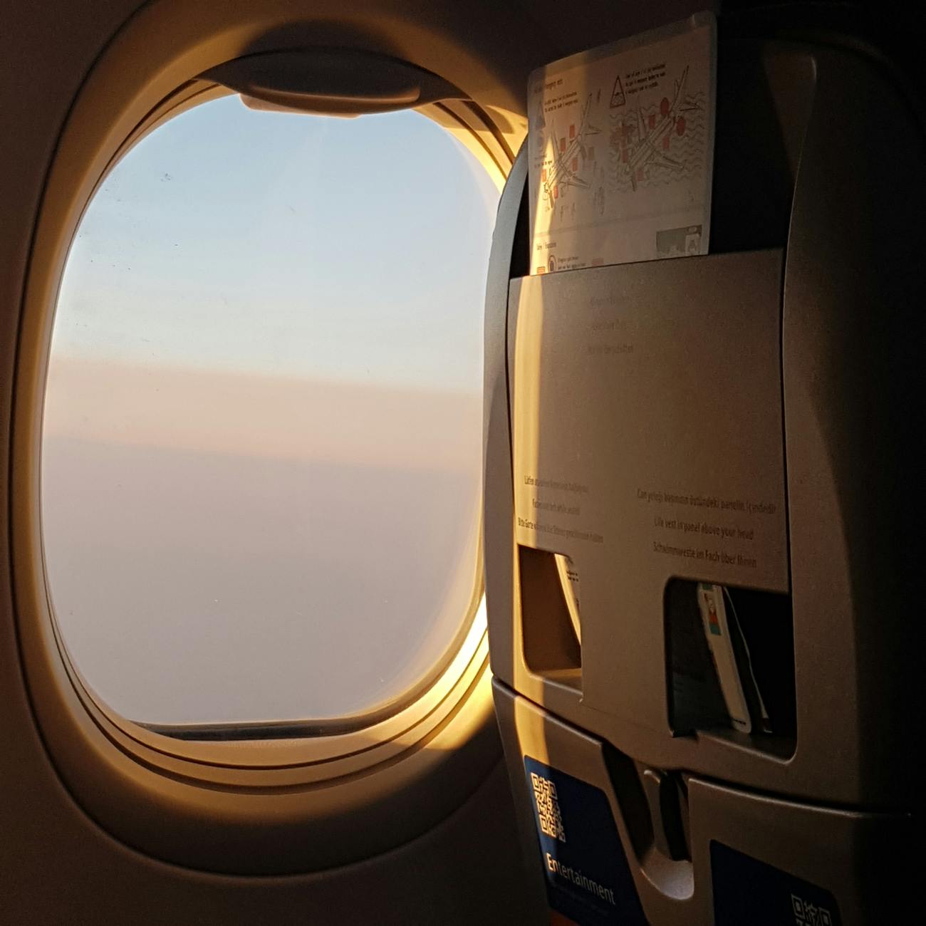 Serene glimpse through airplane window at dawn with soft lighting and tranquil atmosphere.