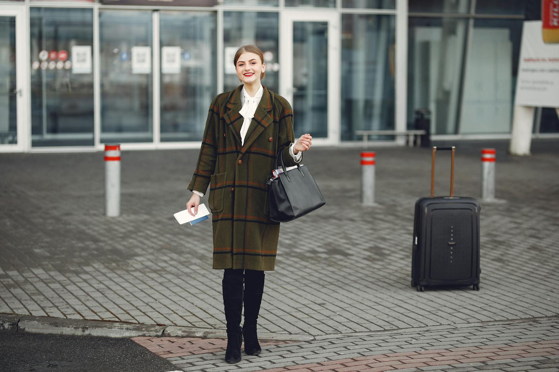 Fashionable woman with luggage arrives at airport ready for travel.