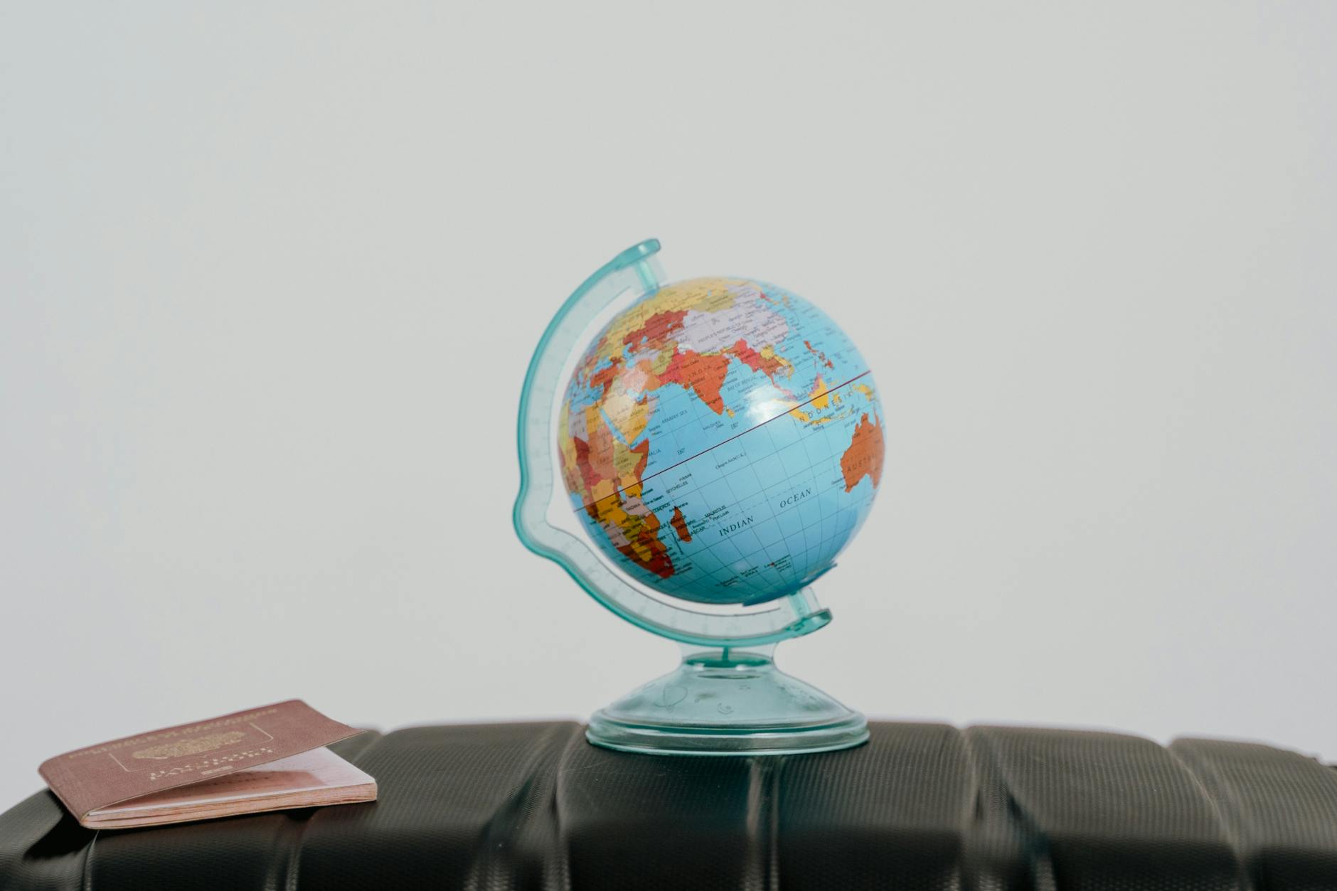 A globe and passport on a suitcase, symbolizing travel planning and wanderlust.