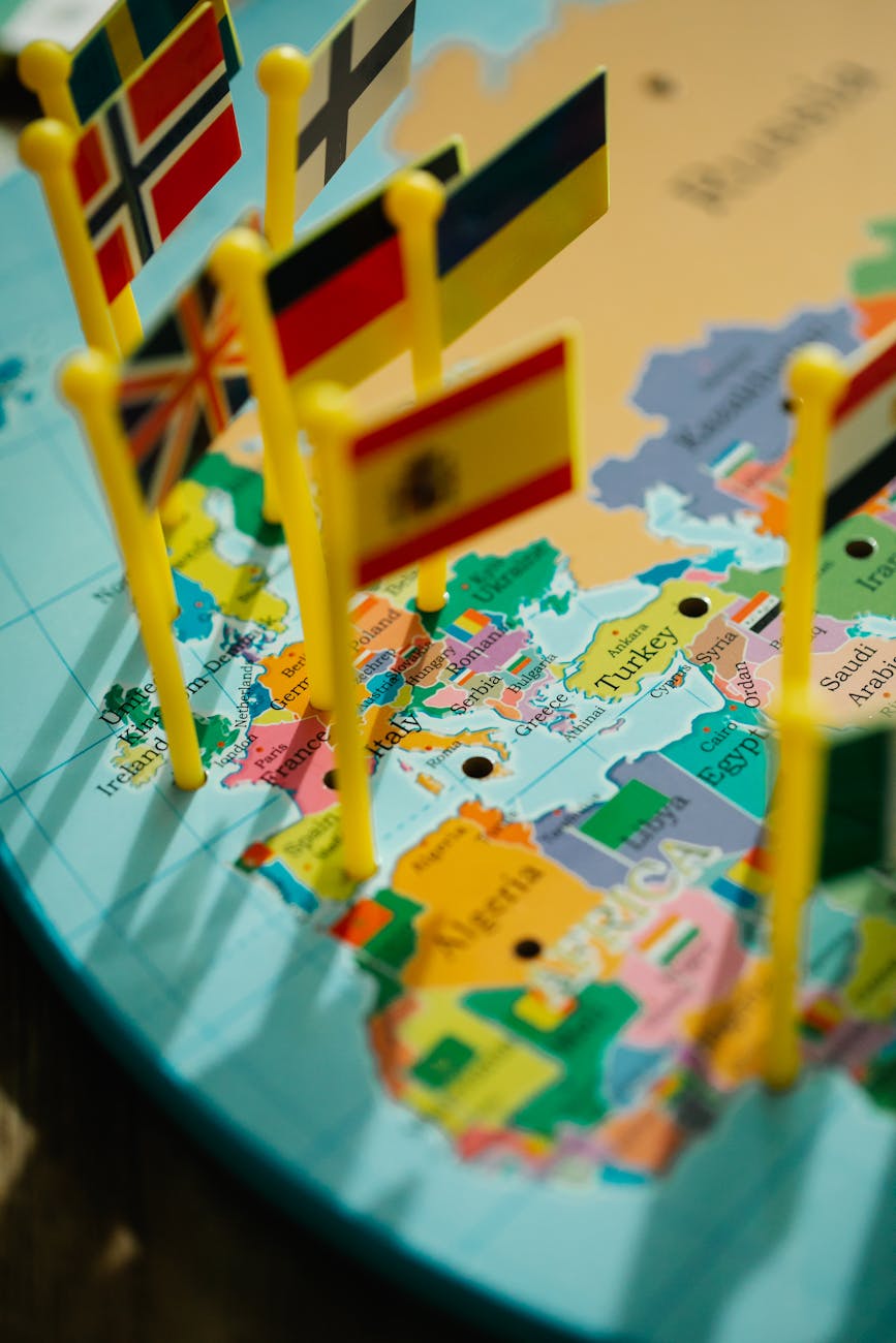 Close-up of a world map with various country flags on pin poles highlighting Europe.