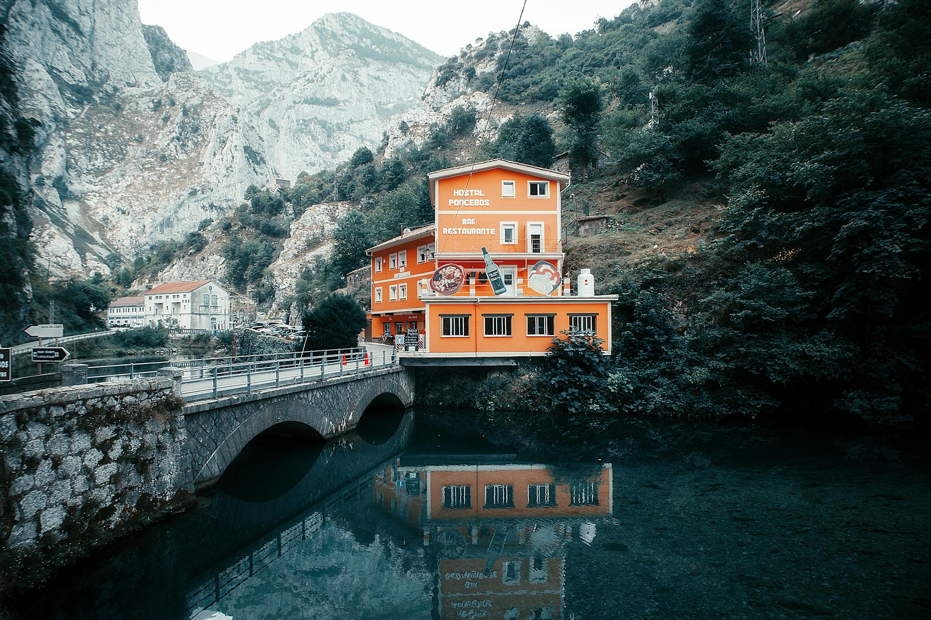 Hostal Poncebos reflecting over the Cares River in the scenic Picos de Europa, Spain.