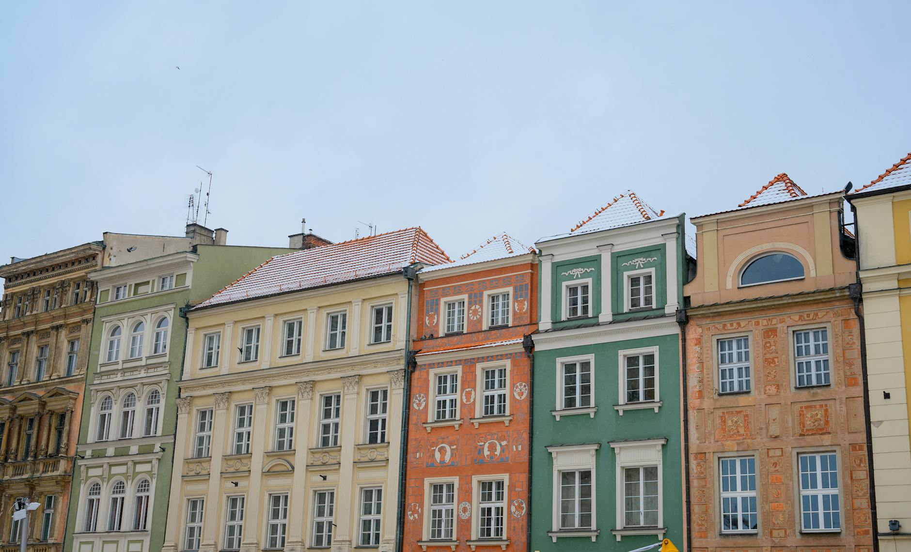Charming row of colorful traditional buildings with ornate facades in European cityscape.
