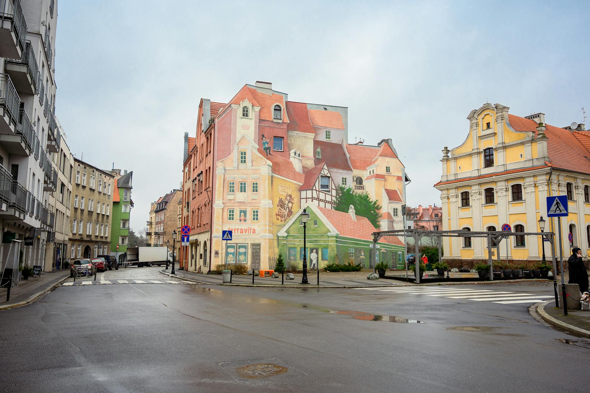 Charming European cityscape featuring colorful murals on historic buildings.