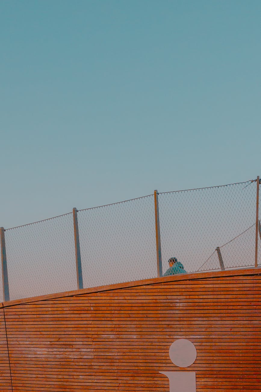 Minimalist urban scene with a fence against a clear sky in Helsinki.