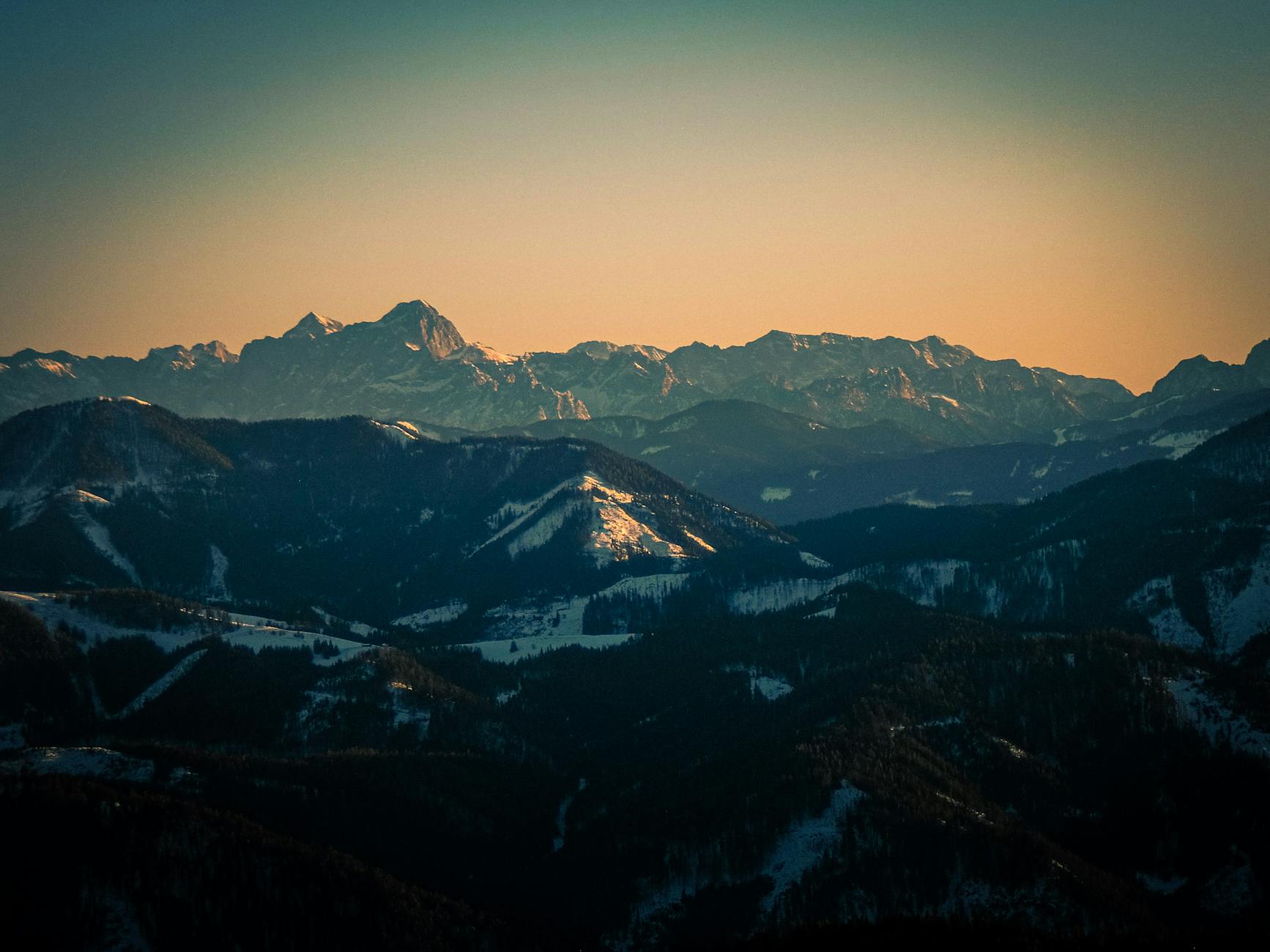Stunning view of a snowy mountain range in Kärnten, Austria during sunrise, showcasing nature's beauty.