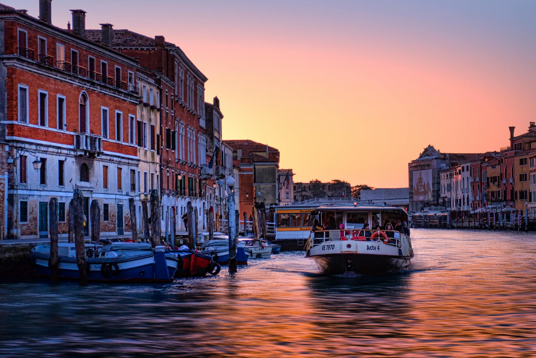 Captivating sunset over Venice's Grand Canal with boats and historic architecture.