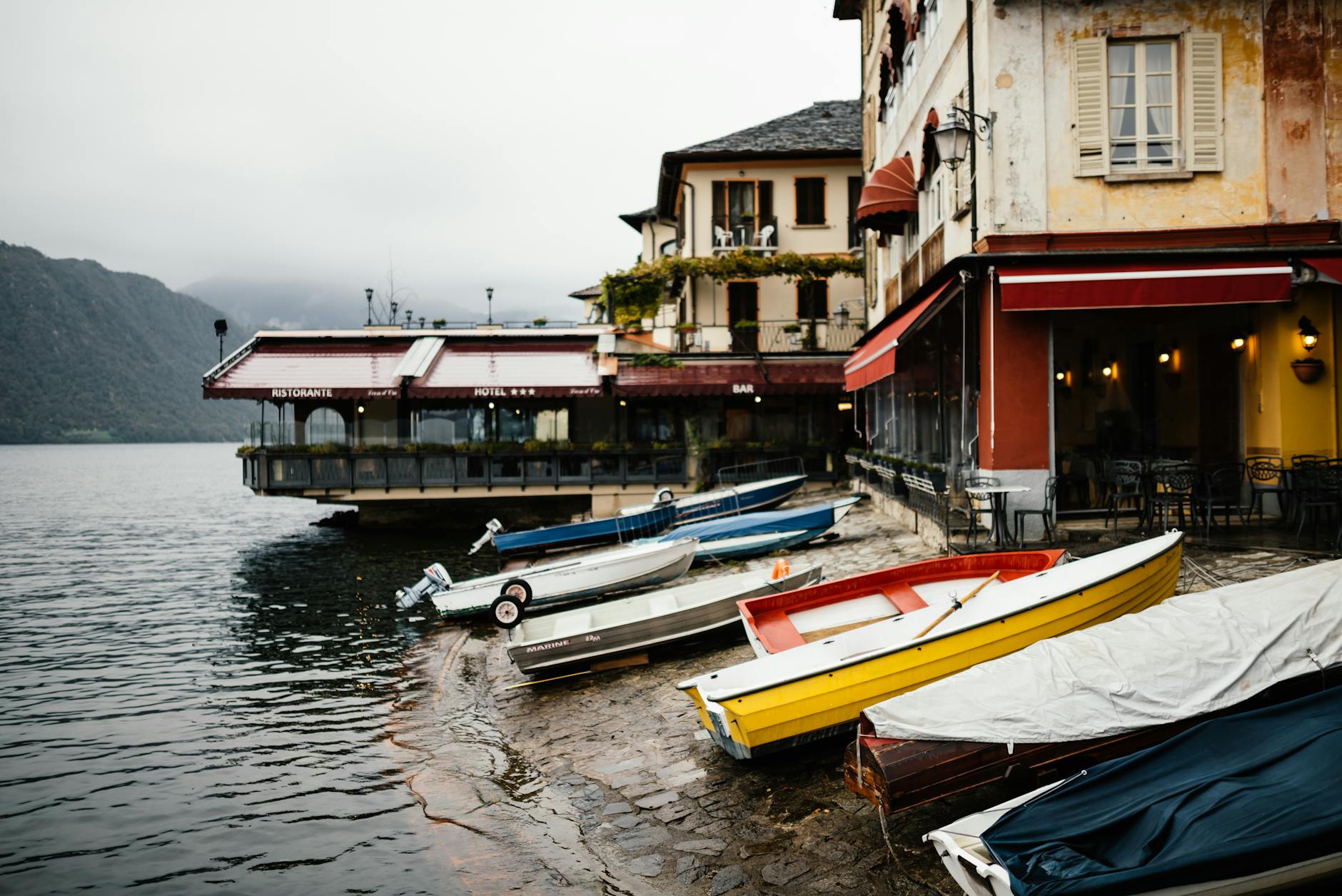 Quaint lakeside scene with docked boats and vintage buildings, perfect for travel-themed projects.