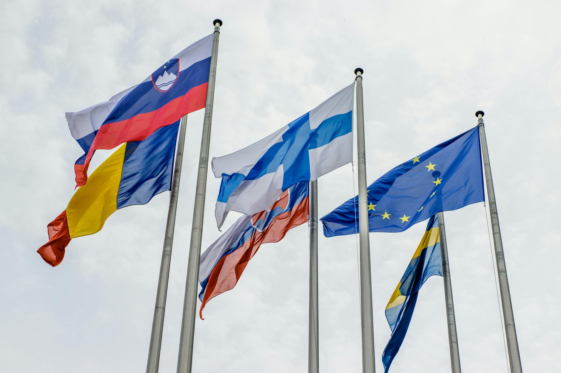 Flags of European countries and the EU waving on flagpoles in Strasbourg.
