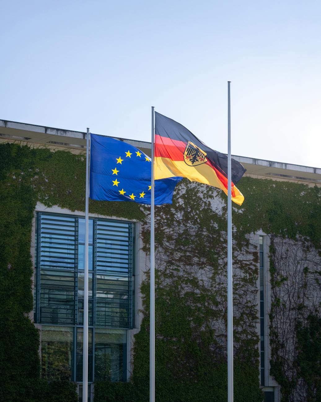 EU and German flags flutter outside the Federal Chancellery in Berlin, Germany.