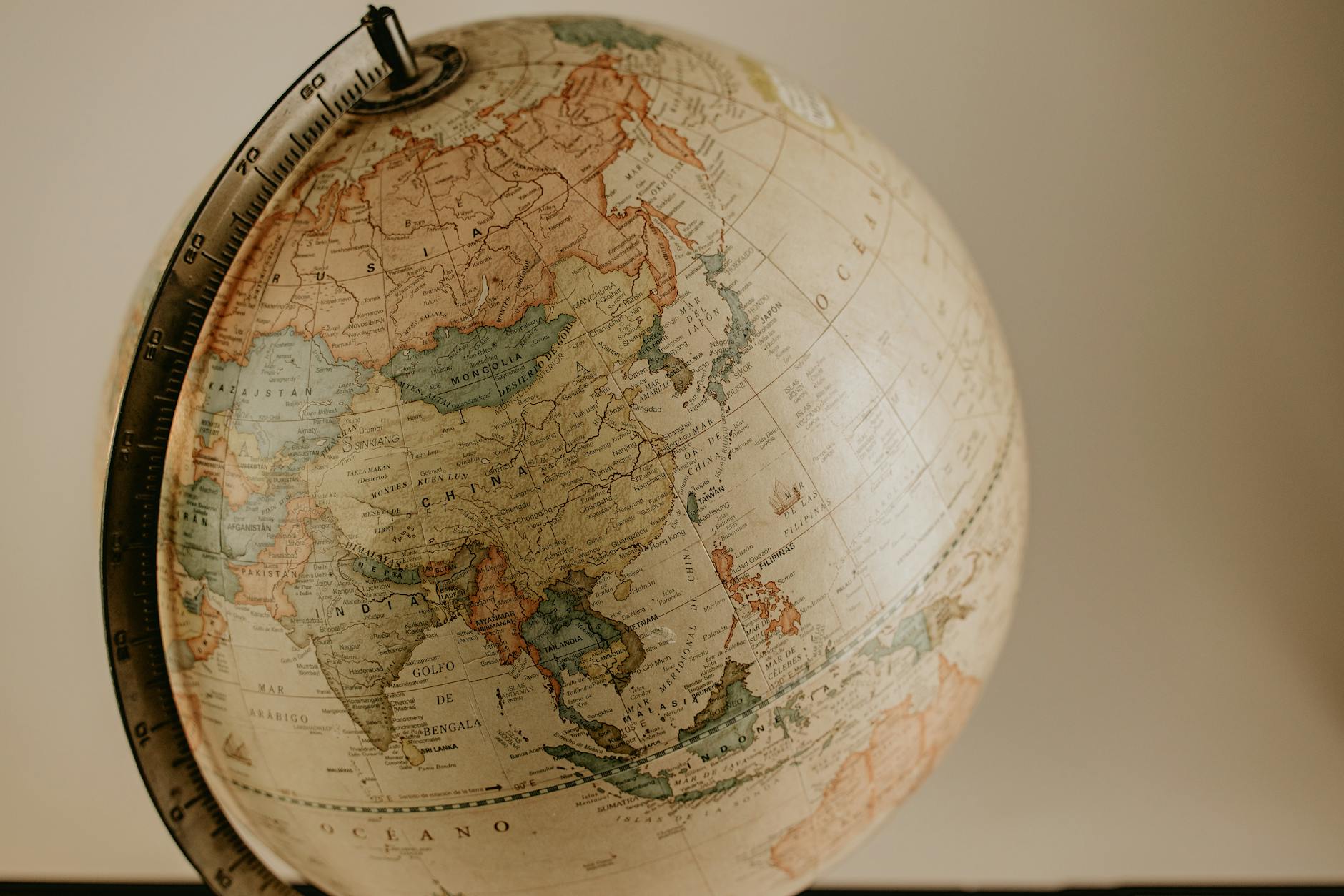 A vintage globe displaying the continents of Asia and Europe in sepia tones, ideal for travel concepts.