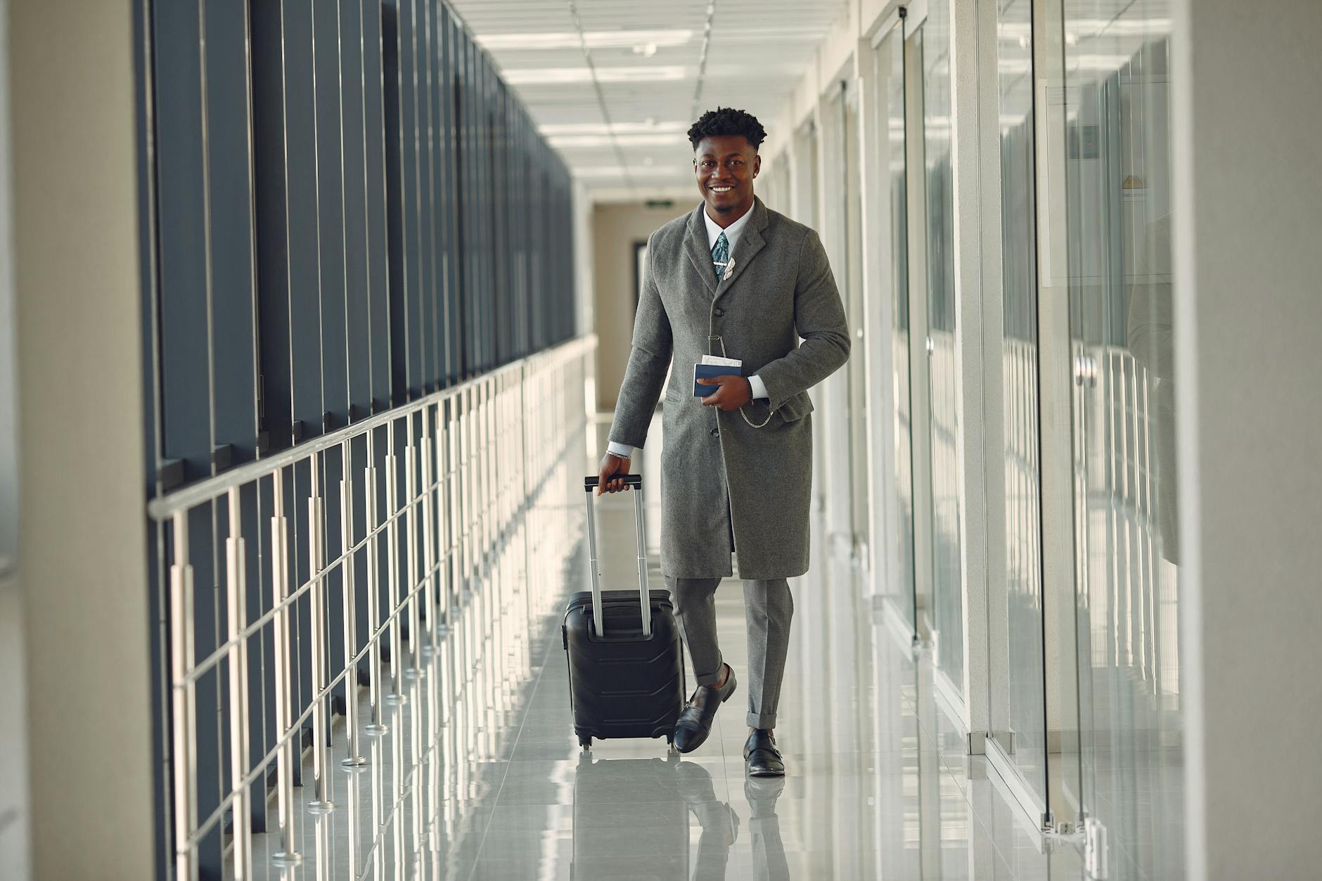 Businessman with luggage walking in an airport corridor, exuding confidence and professionalism.