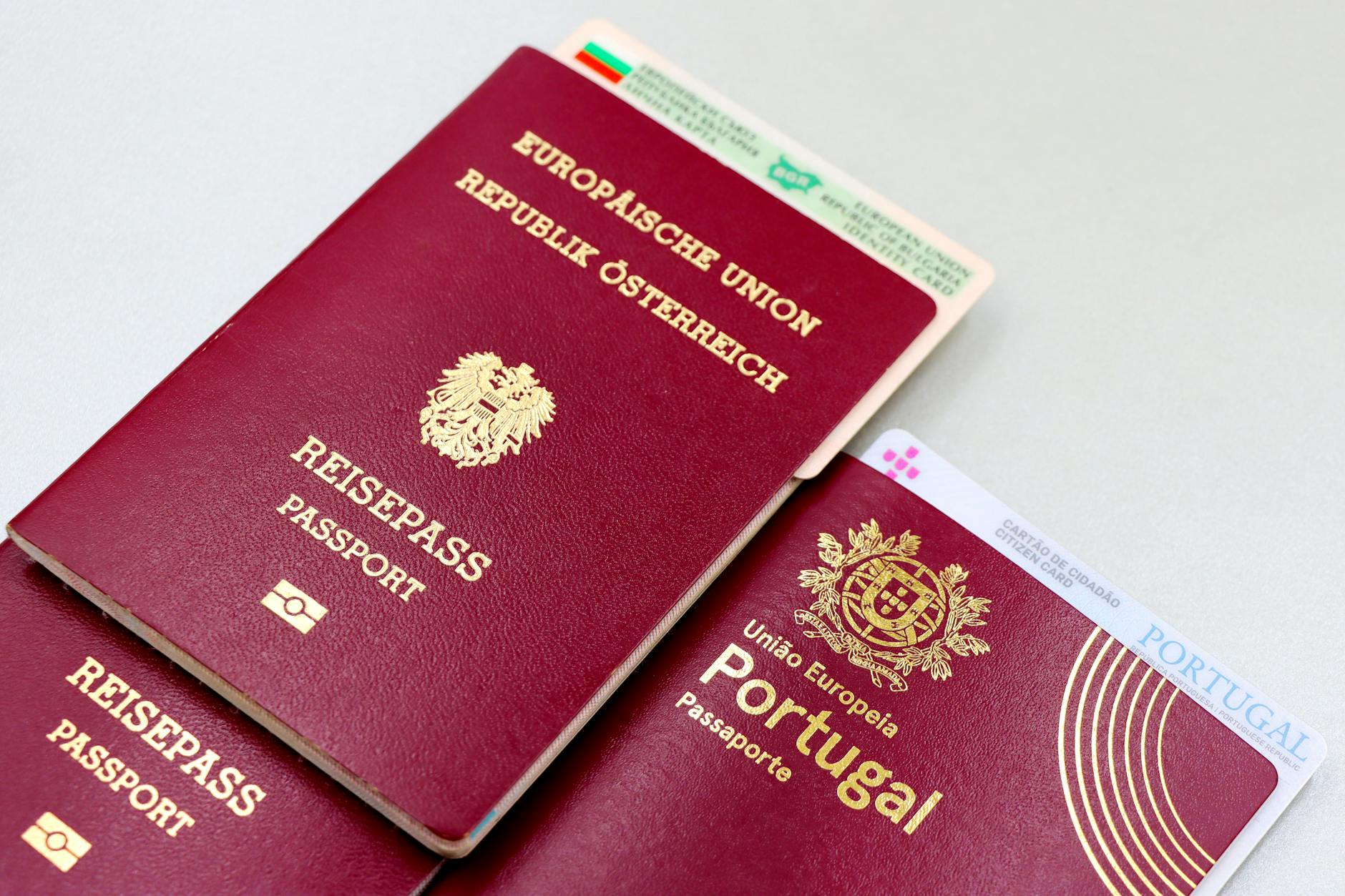 A close-up image of Austrian and Portuguese passports with a Bulgarian ID card.