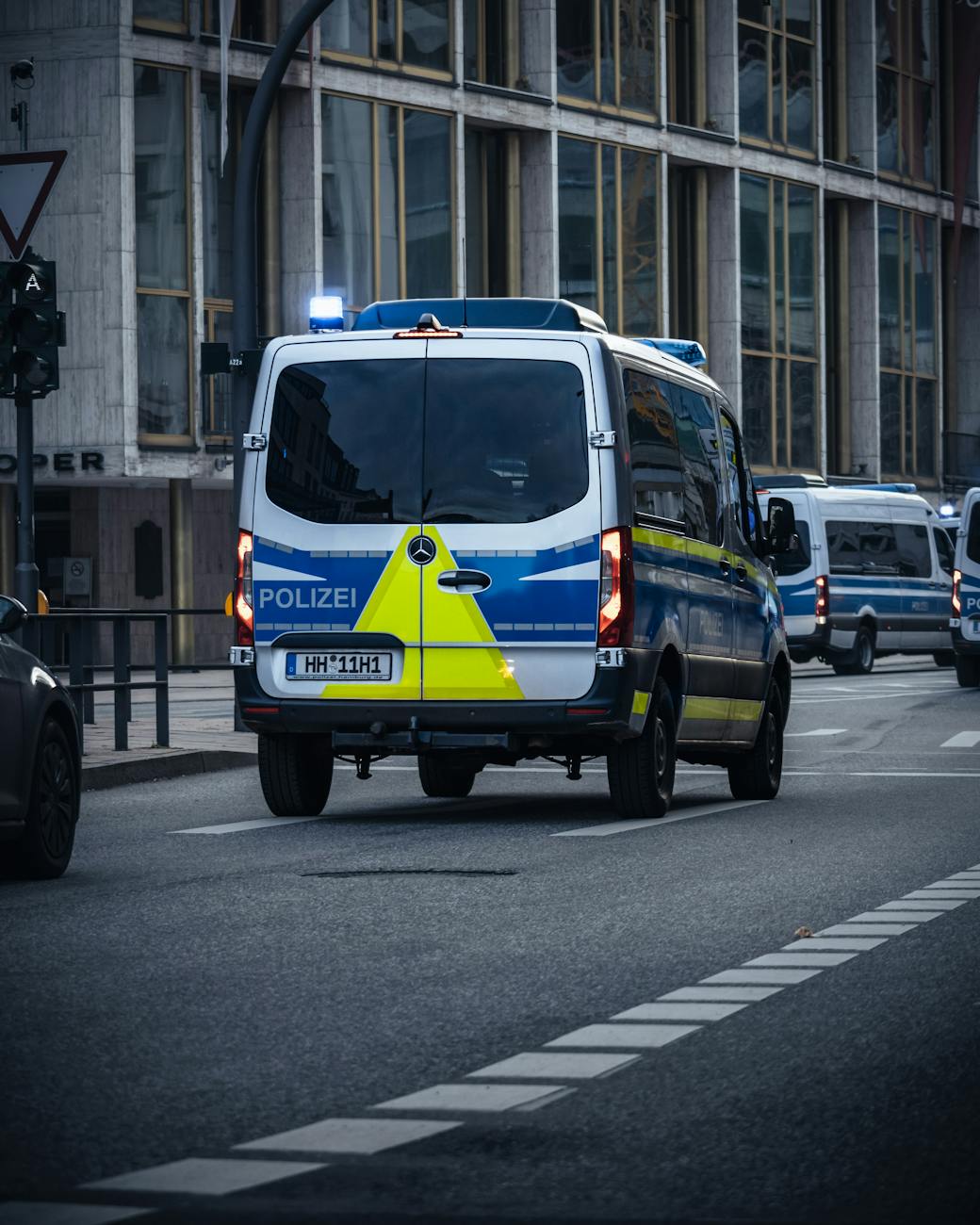 Police vans parked on a city street ready for emergency response in an urban setting.