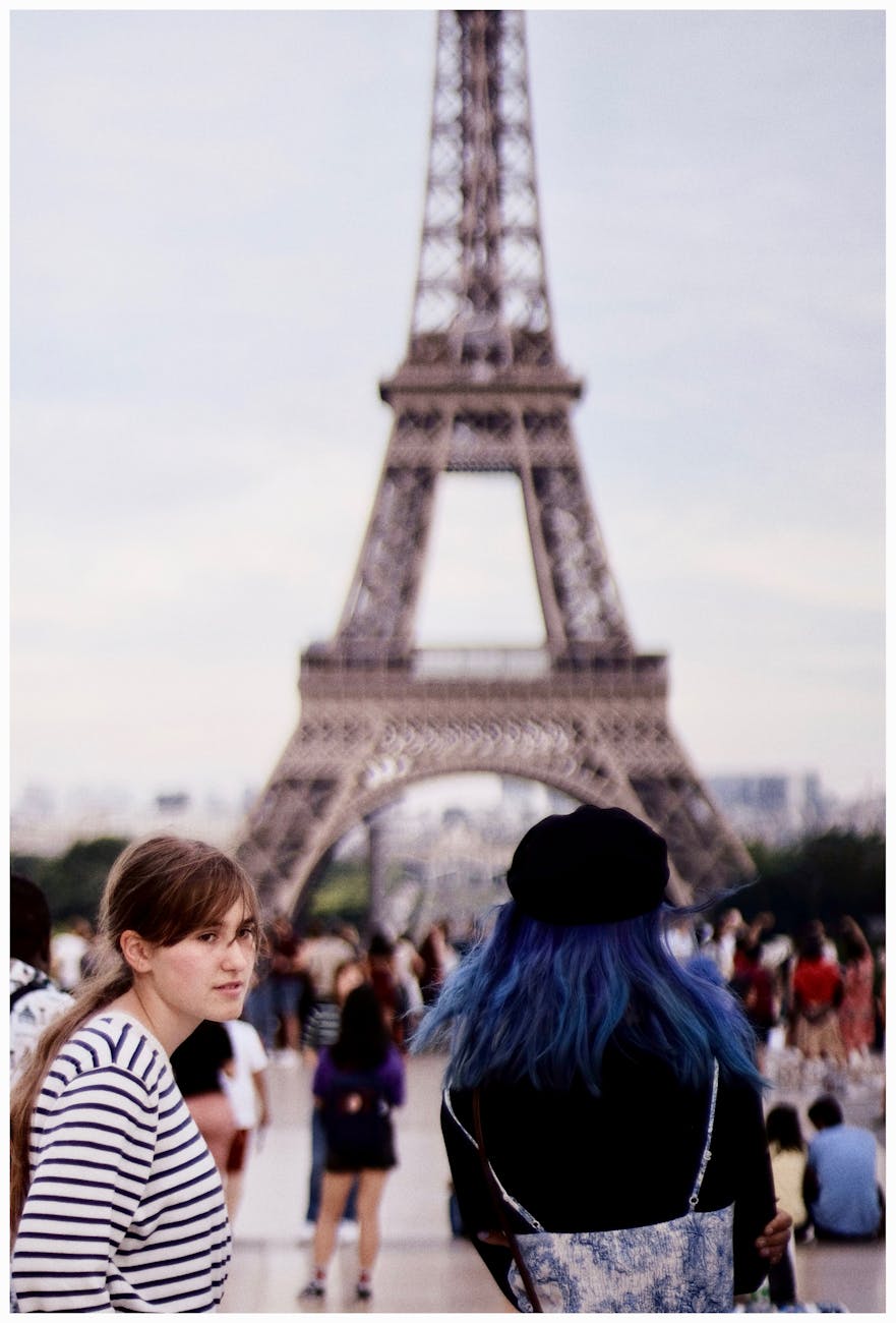 Tourists with blue and brown hair exploring the famous Eiffel Tower in Paris.