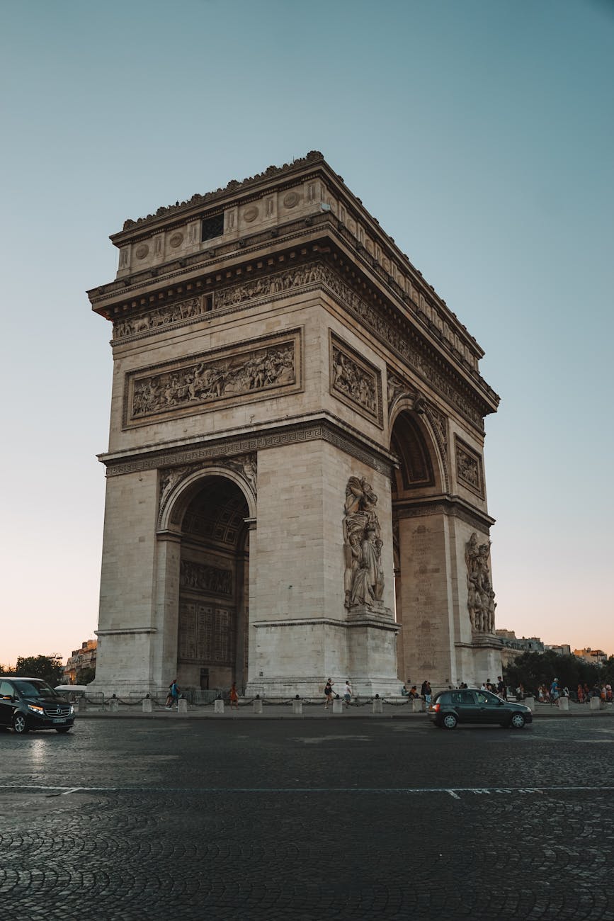 A stunning view of the Arc de Triomphe in Paris captured during the golden hour, highlighting its architectural beauty.