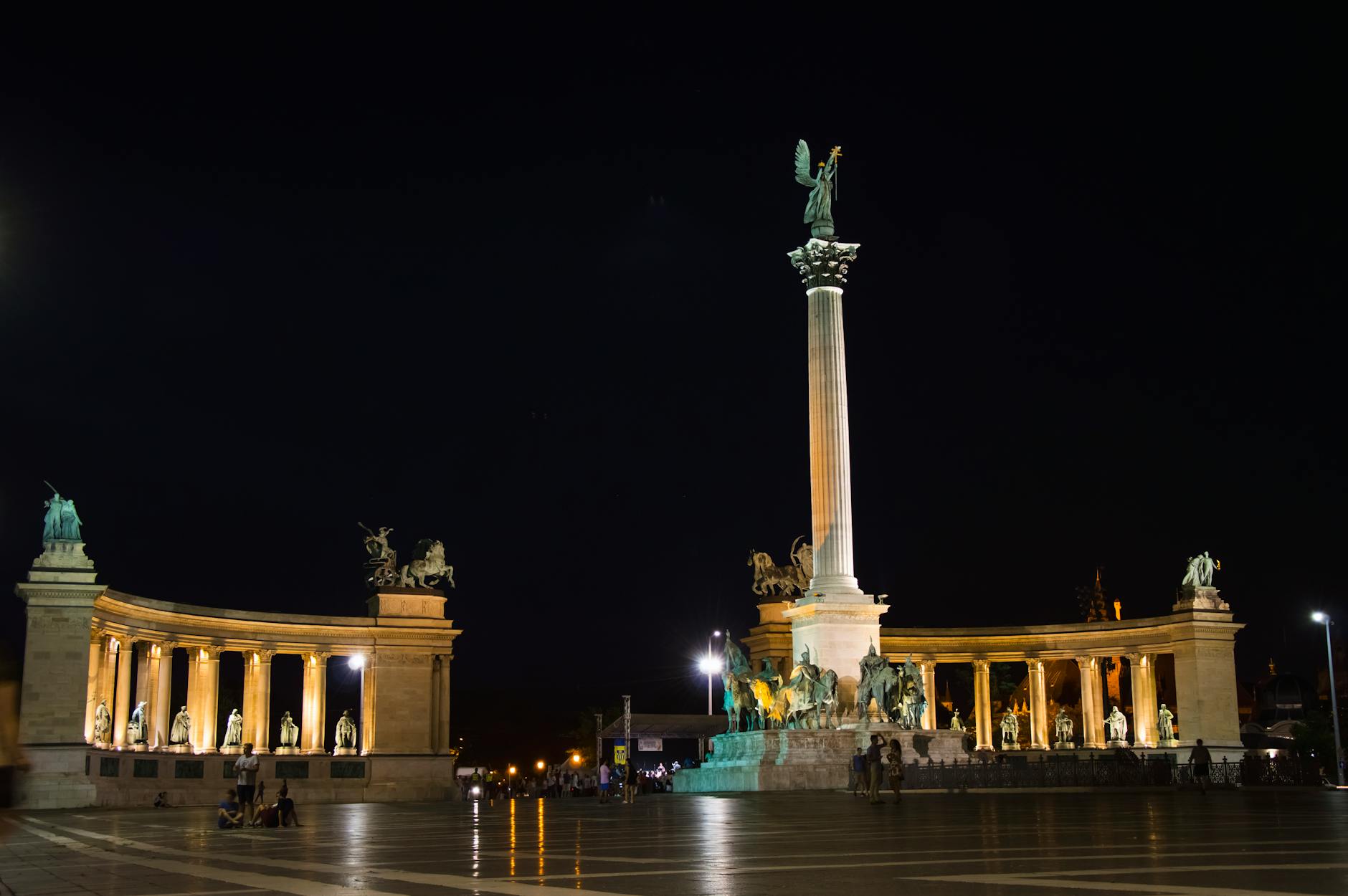Iconic Heroes' Square in Budapest showcases grand statues illuminated at night.