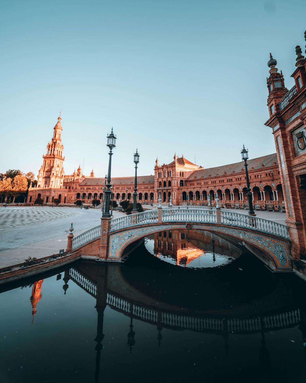 Explore the beautiful architecture of Plaza de España in Seville, Spain during sunrise.