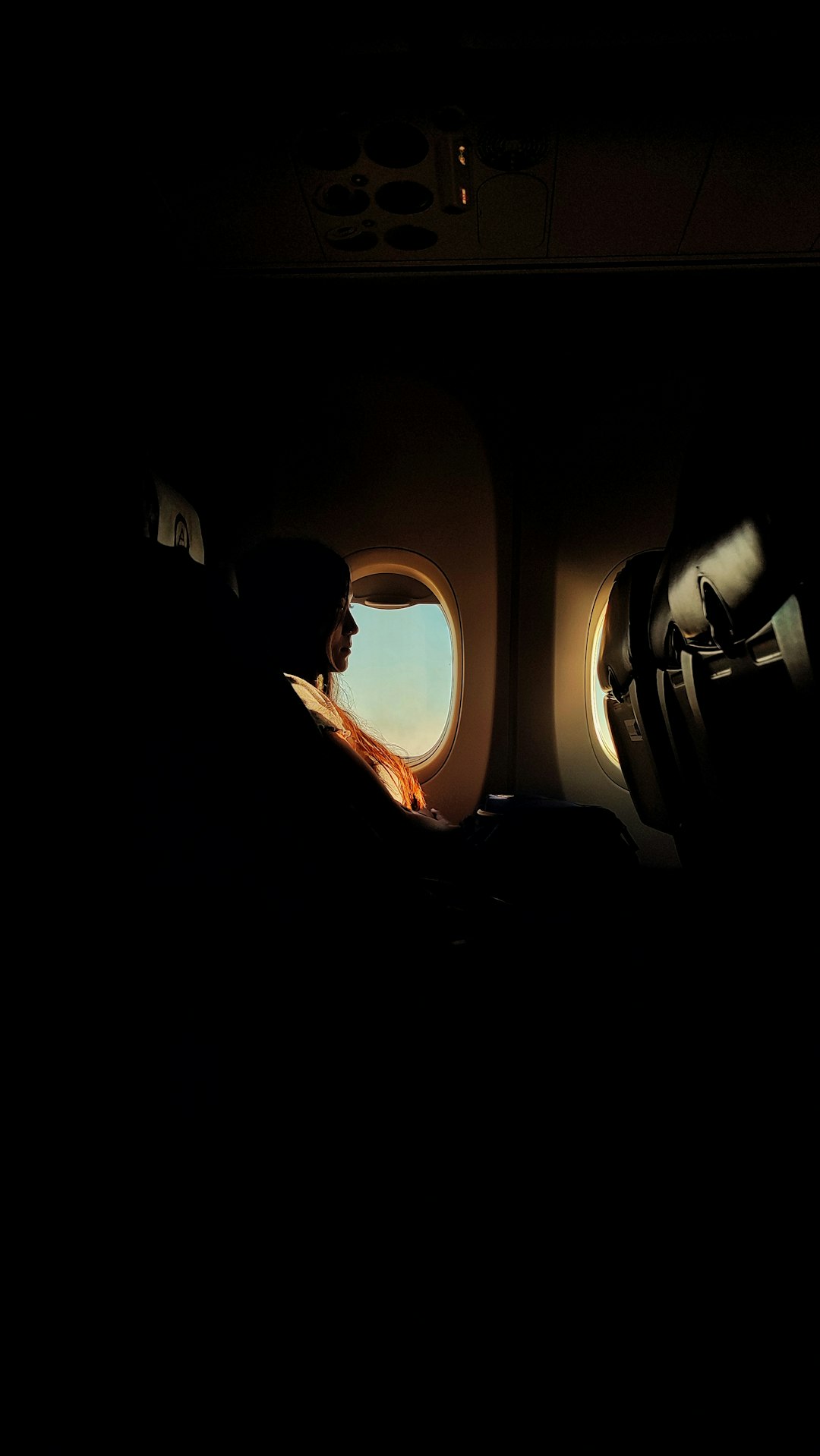 a man sitting in an airplane looking out the window
