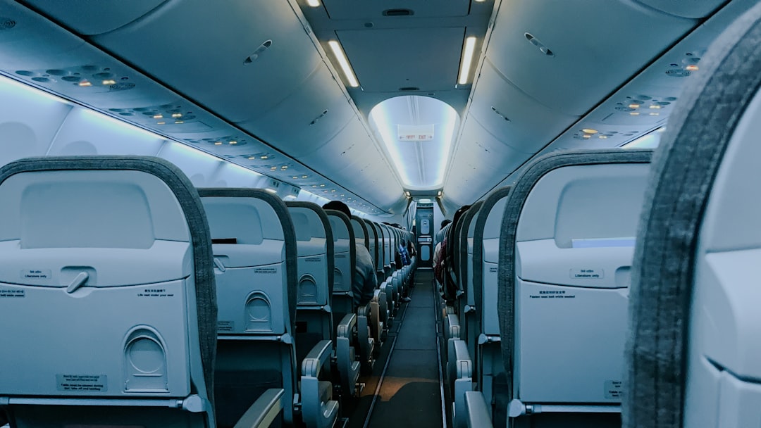 The inside of an airplane with rows of empty seats